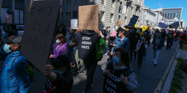 Demonstrators hold up signs as they take part in an anti-Asian American hate march and rally at San Francisco City Hall March 27, 2021. 