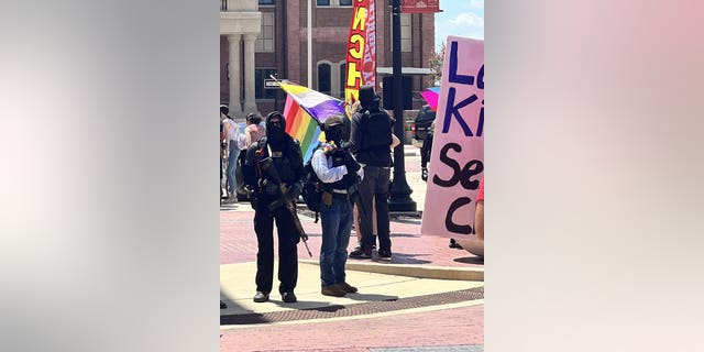 Masked protesters outside a drag brunch at Anderson Distillery &amp; Grill in Roanoke, Texas.