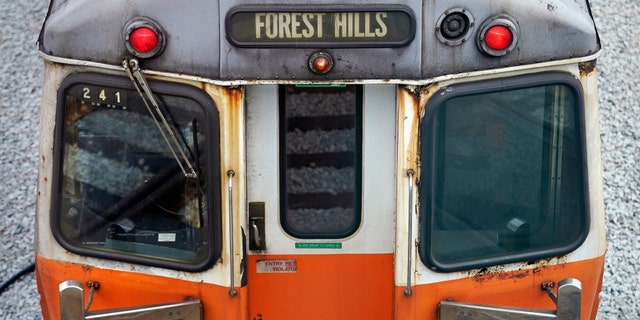 An older subway car, with spots of rust on the exterior shell, is parked with lights on at the Orange Line's Wellington Station train yard in Medford, Mass. Transit officials are taking what they describe as the "unprecedented" step of shuttering one of Boston’s four major subway lines for 30 days to allow for track and signal work.