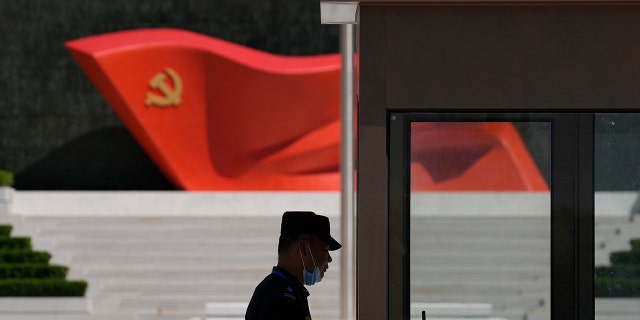 A security guard stands near a sculpture of the Chinese Communist Party flag at the Museum of the Communist Party of China on May 26, 2022 in Beijing.