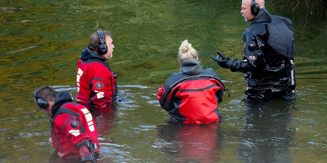 Water recovery authorities comb the Apple River with metal detectors after five people were stabbed while tubing, Saturday, July 30, 2022, in Somerset, Wis. 
