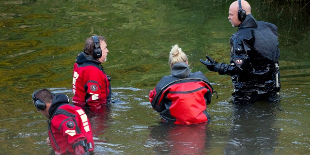 Water recovery authorities comb the Apple River with metal detectors after five people were stabbed while tubing, Saturday, July 30, 2022, in Somerset, Wis. 