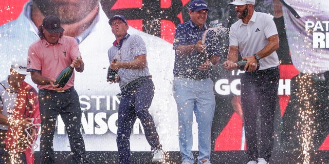 The "4 Aces" team celebrates with champagne after winning the team competition during a ceremony after the final round of the Bedminster Invitational LIV Golf tournament in Bedminster, New Jersey, on Sunday, July 31, 2022. From left, Pat Perez, Talor Gooch, Patrick Reed and Dustin Johnson.