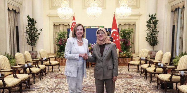 In this photo provided by Ministry of Communications and Information, Singapore, U.S. House Speaker Nancy Pelosi, left, and Singapore President Halimah Yacob shake hands at the Istana Presidential Palace in Singapore, Monday, Aug. 1, 2022. Pelosi arrived in Singapore early Monday, kicking off her Asian tour as questions swirled over a possible stop in Taiwan that has fueled tension with Beijing.