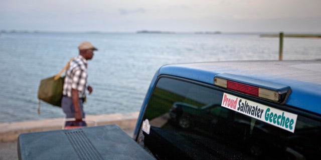 A sticker celebrating the Geechee heritage is seen on a pickup truck as passengers board a ferry to the mainland on Sapelo Island, Georgia. An enclave of slave descendants on the Georgia coast has settled a federal lawsuit that claimed a lack of government services was eroding their island community, one of the few remaining Gullah-Geechee settlements on the Southeast U.S. coast.