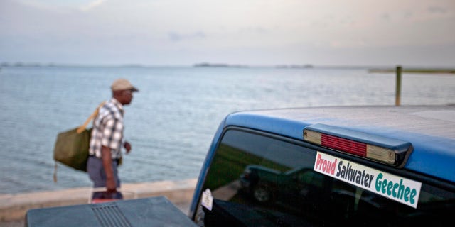 A sticker celebrating the Geechee heritage is seen on a pickup truck as passengers board a ferry to the mainland on Sapelo Island, Georgia. An enclave of slave descendants on the Georgia coast has settled a federal lawsuit that claimed a lack of government services was eroding their island community, one of the few remaining Gullah-Geechee settlements on the Southeast U.S. coast.
