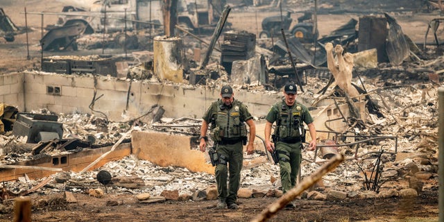 Sheriff's deputies leave a home where a McKinney Fire victim was found on Monday, Aug. 1, 2022, in Klamath National Forest, California.