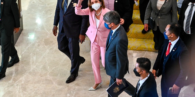 这张由马来西亚新闻部拍摄并发布的讲义照片，美国众议院议长南希佩洛西（中）于 2022 年 8 月 2 日星期二参观吉隆坡的国会大厦时向媒体挥手致意。