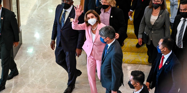 This handout photo taken and released by Malaysia’s Department of Information, U.S. House Speaker Nancy Pelosi, center, waves to media as she tours the parliament house in Kuala Lumpur, Tuesday, Aug. 2, 2022.