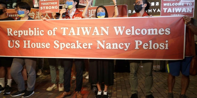 Supporters hold a banner outside the hotel where U.S. House Speaker Nancy Pelosi is supposed to be staying in Taipei, Taiwan, Tuesday, Aug 2, 2022. U.S. House Speaker Nancy Pelosi was believed headed for Taiwan on Tuesday on a visit that could significantly escalate tensions with Beijing, which claims the self-ruled island as its own territory. 