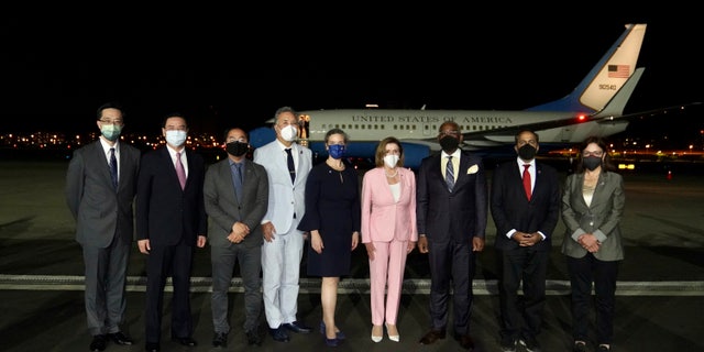 In this photo released by the Taiwan Ministry of Foreign Affairs, US House Speaker Nancy Pelosi, center pose for photos after she arrives in Taipei, Taiwan, Tuesday, Aug. 2, 2022. Pelosi arrived in Taiwan on Tuesday night despite threats from Beijing of serious consequences, becoming the highest-ranking American official to visit the self-ruled island claimed by China in 25 years.