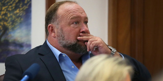 Alex Jones attempts to answer questions about his text messages asked by Mark Bankston, lawyer for Neil Heslin and Scarlett Lewis, during trial at the Travis County Courthouse in Austin, Texas, on Aug. 3, 2022.