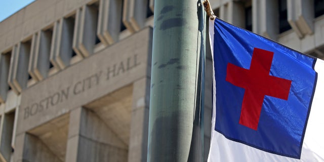 The Christian flag that became the focus of a free speech legal battle that went all the way to the Supreme Court was raised briefly outside Boston City Hall on Wednesday to cheers and songs of praise.