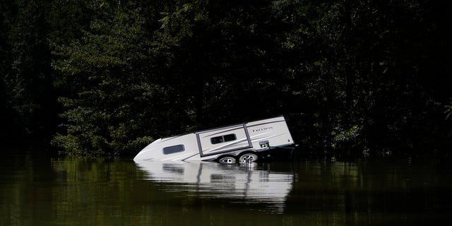 A camper is seen partially submerged underwater in Carr Creek Lake near Hazard, Kentucky. Kentucky flood survivors are looking for drinking water as it is scarce in the area.