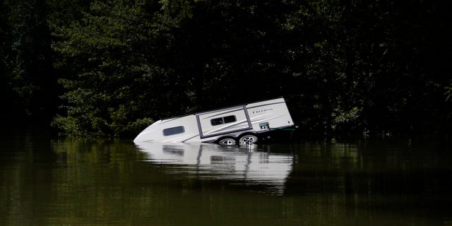 A camper is seen partially submerged underwater in Carr Creek Lake near Hazard, Kentucky. Kentucky flood survivors are looking for drinking water as it is scarce in the area.