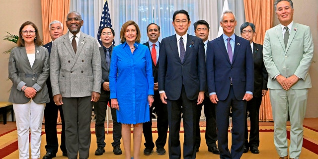 Předsedkyně Sněmovny reprezentantů Nancy Pelosiová, vpředu, vlevo uprostřed, a její delegace Kongresu pózují na fotografii s japonským premiérem Fumiem Kishidou vpravo uprostřed před snídaní v oficiální rezidenci premiéra v Tokiu.