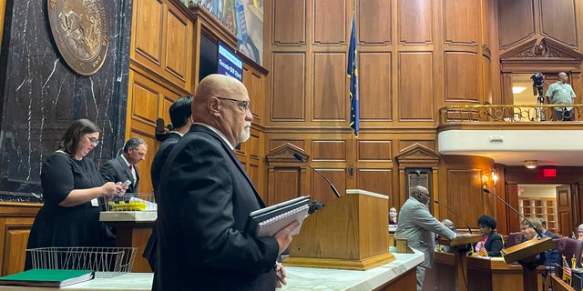 Republican Rep. Tim Brown, center, listens to Democratic Rep. Gregory Porter, right, speak at the Statehouse in Indianapolis on a bill that would issue $200 rebate payments to taxpayers and allocate $45 million more in the coming year toward state agencies that support families, young children and people who adopt.