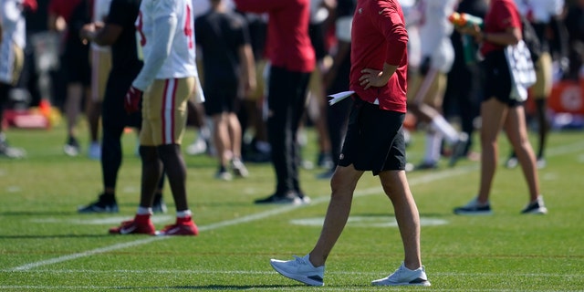 San Francisco 49ers head coach Kyle Shanahan watches as players take part in drills at the team's practice facility in Santa Clara, California, on Friday, Aug. 5, 2022.