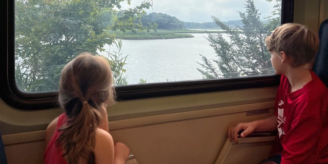 Children look out a train window aboard the Cape Flyer, a weekend passenger train to Cape Cod. It runs during the weekends of summer until Labor Day, from Boston to Hyannis, with a handful of stops in between. 