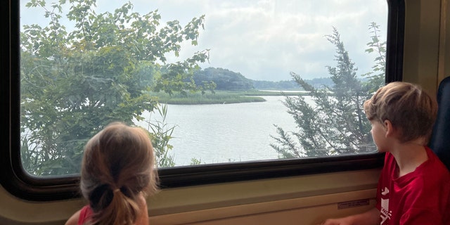 Children look out a train window aboard the Cape Flyer, a weekend passenger train to Cape Cod. It runs during the weekends of summer until Labor Day, from Boston to Hyannis, with a handful of stops in between.