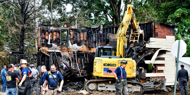 Crews work to demolish a house that was destroyed by a fatal fire on the 700 block of 1st Street in Nescopeck, Pa., on Aug. 5, 2022. Multiple people are feared dead after a house fire early Friday in northeastern Pennsylvania, according to a volunteer firefighter who responded and said the victims were his relatives.