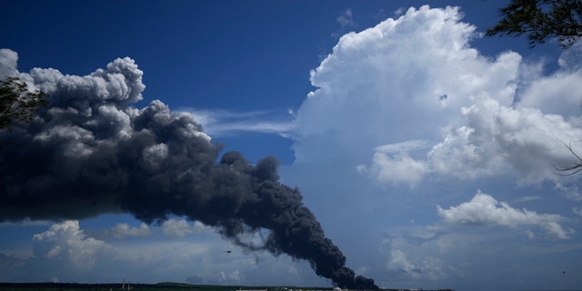 Een grote rookpluim stijgt op vanaf het Madanzas-supertankerdek terwijl brandweerlieden werken aan het blussen van een brand die de nacht ervoor, zaterdag 6 augustus 2022, uitbrak tijdens een onweersbui in Madazanas, Cuba.