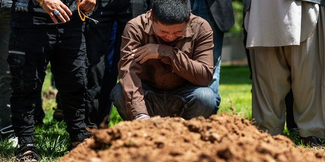 Altaf Hussain cries over the grave of his brother Aftab Hussein at Fairview Memorial Park in Albuquerque, N.M., el viernes, ago. 5, 2022. A funeral service was held for Aftab Hussein, 41, and Muhammad Afzaal Hussain, 27, at the Islamic Center of New Mexico on Friday.