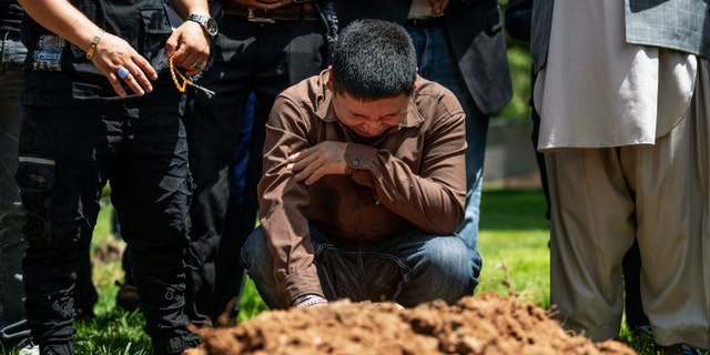 Altaf Hussain cries over the grave of his brother Aftab Hussein at Fairview Memorial Park in Albuquerque, N.M., on Friday, Aug. 5, 2022. A funeral service was held for Aftab Hussein, 41, and Muhammad Afzaal Hussain, 27, at the Islamic Center of New Mexico on Friday. 