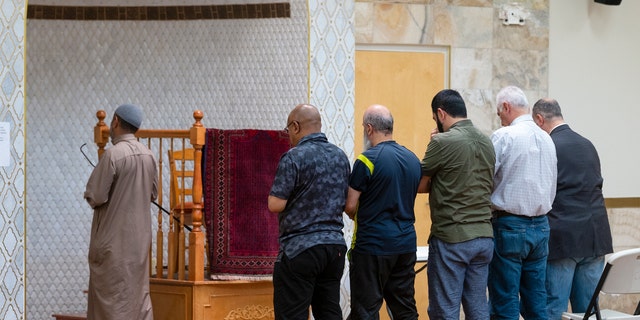 An Imam leads a group of men during the Dhuhr afternoon prayer at the Islamic Center of New Mexico in Albuquerque, New Mexico, Sunday, Aug. 7, 2022, after the fourth Muslim man was murdered in the city.