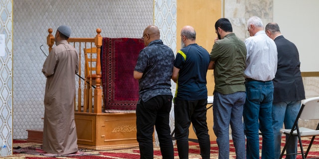 An Imam leads a group of men during the Dhuhr afternoon prayer at the Islamic Center of New Mexico in Albuquerque, New Mexico, Sunday, Aug. 7, 2022, after the fourth Muslim man was murdered in the city.