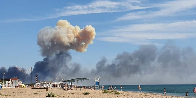 Rising smoke can be seen from the beach at Saky after explosions were heard from the direction of a Russian military airbase near Novofedorivka, Crimea, Tuesday Aug. 9, 2022. 