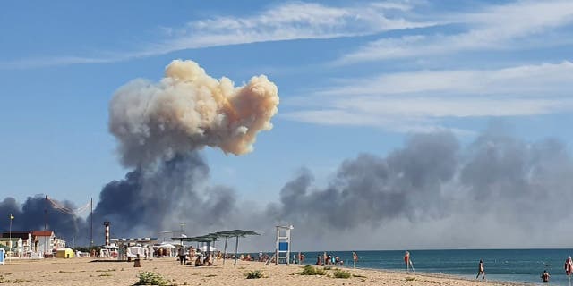 Rising smoke can be seen from the beach at Saky after explosions were heard from the direction of a Russian military airbase near Novofedorivka, Crimea, Tuesday Aug. 9, 2022. The explosion of munitions caused a fire at a military air base in Russian-annexed Crimea Tuesday but no casualties or damage to stationed warplanes, Russia's Defense Ministry said. 