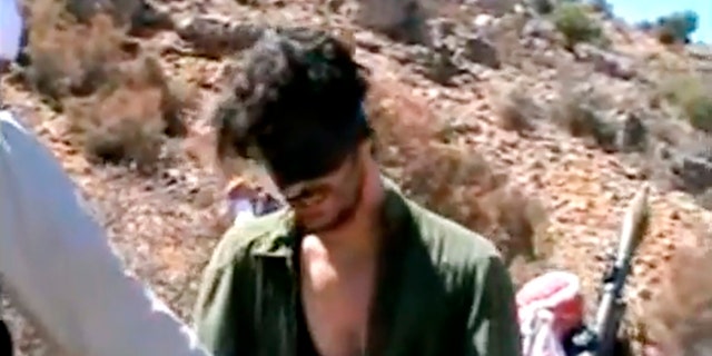 In this image from an undated video posted on YouTube, American freelance journalist Austin Tice, who had worked for American news outlets in Syria until his disappearance in August 2012, prays in Arabic and English while blindfolded in the presence of men. armed.