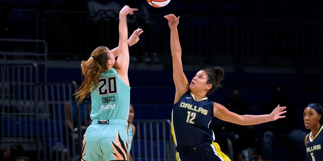 New York Liberty guard Sabrina Ionescu has her shot blocked by Dallas Wings guard Veronica Burton during the first half of a WNBA basketball game in Arlington, Texas, on Aug. 10, 2022. The Liberty's playoff hopes remain after a Dallas win.