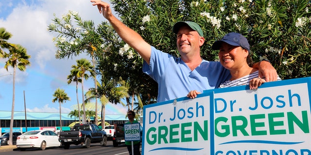 Hawaii Lt. Gov. Josh Green, left, and his wife, Jamie, greet passing cars while campaigning in Honolulu on Aug. 2, 2022. 