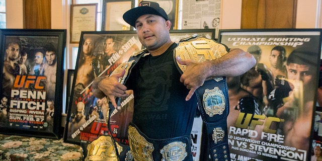 BJ Penn poses with all five of his UFC championship belts and several of his fight posters at his family's home on May 30, 2015, in Hilo, Hawaii. 