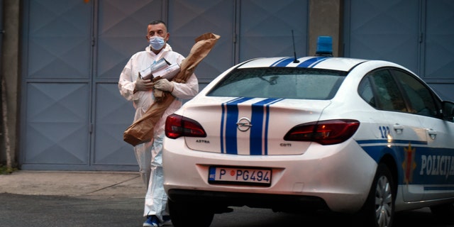 A police investigator holds evidence material on the site of the attack in Cetinje, Montenegro, Friday, Aug. 12, 2022. A man went on a shooting rampage in the streets of a western Montenegro city Friday, killing multiple people, before being shot dead by a passerby, officials said.