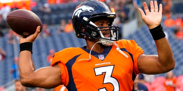 Denver Broncos quarterback Russell Wilson warms up against the Dallas Cowboys in Denver on Aug. 13, 2022.