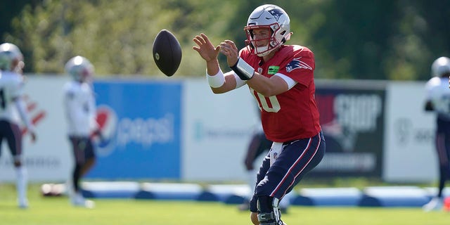 New England Patriots quarterback Mac Jones warms up during a joint practice with the Carolina Panthers, Tuesday, Aug. 16, 2022, in Foxborough.