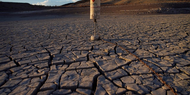 A buoy sits high and dry on cracked earth previously under the waters of Lake Mead at the Lake Mead National Recreation Area near Boulder City, Nev., on June 28, 2022. (AP Photo/John Locher)