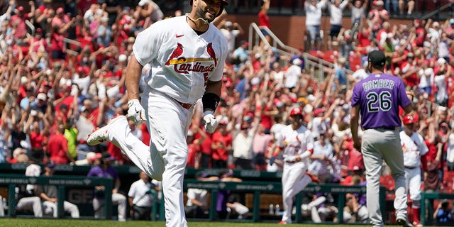 St. Louis Cardinals' Albert Pujols, left, rounds the bases after hitting a grand slam off Colorado Rockies starting pitcher Austin Gomber, #26, during the third inning of a baseball game Thursday, Aug. 18, 2022, in St. Louis. 
