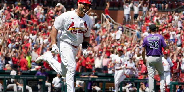 St. Louis Cardinals' Albert Pujols, left, rounds the bases after hitting a grand slam off Colorado Rockies starting pitcher Austin Gomber, #26, during the third inning of a baseball game Thursday, Aug. 18, 2022, in St. Louis.