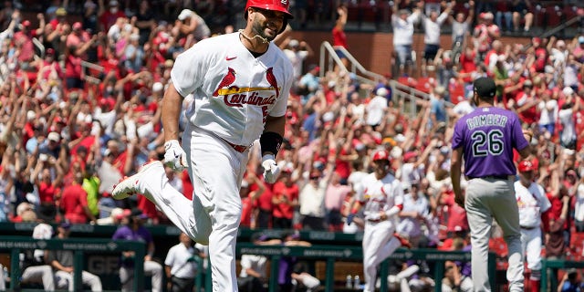 St. Louis Cardinals' Albert Pujols, left, rounds the bases after hitting a grand slam off Colorado Rockies starting pitcher Austin Gomber, #26, during the third inning of a baseball game Thursday, Aug. 18, 2022, in St. Louis. 