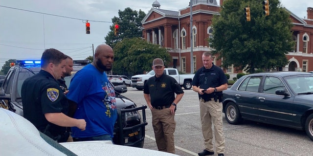 Troup County Sheriff's Office police take Jerel Raphael Brown into custody on Aug. 17, 2022 in LaFayette, Alabama. Brown, 39, of Montgomery was arrested without incident Wednesday near the courthouse in LaFayette with more than 2,000 rounds of ammunition and an alarming number of firearms in his 1996 white Cadillac Fleetwood according to police. 