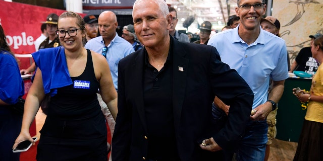 Former Vice President Mike Pence walks through the Varied Industries Building during a visit to the Iowa State Fair, Friday, Aug. 19, 2022, in Des Moines, Iowa.