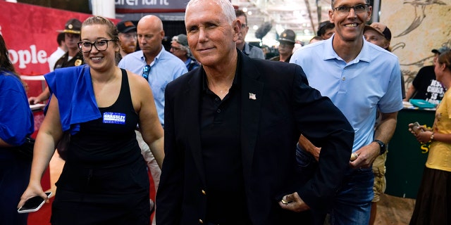 Former Vice President Mike Pence walks through various industrial buildings during a visit to the Iowa State Fair in Des Moines, Iowa, Friday, Aug. 19, 2022. 