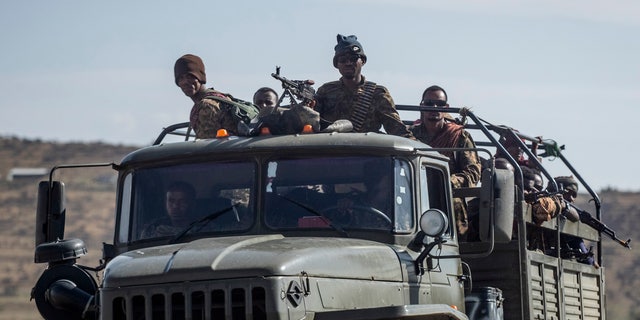 Ethiopian government soldiers travel in the back of a truck on a road near Agula, north of Mekele, in the Tigray region of northern Ethiopia on May 8, 2021.
