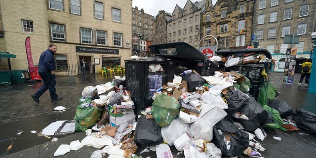 A view of overflowing bins in the Grassmarket area of Edinburgh where cleansing workers from the City of Edinburgh Council are on the fourth day of eleven of strike action, in Scotland, Wednesday, Aug. 24, 2022.