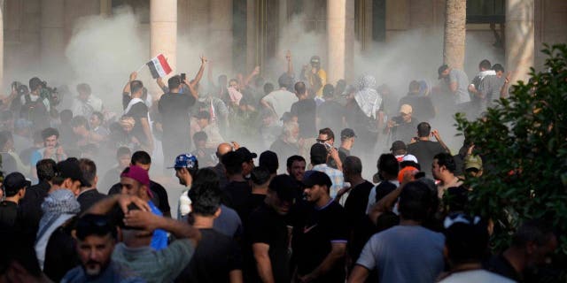 Iraqi security forces fire tear gas on the followers of Shiite cleric Muqtada al-Sadr inside the government Palace, Baghdad, Iraq, Monday, Aug. 29, 2022.