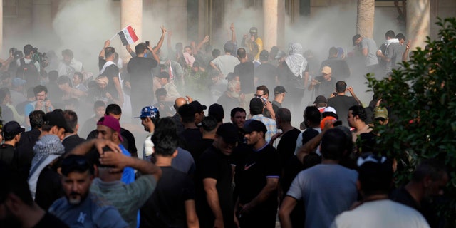 Iraqi security forces fire tear gas on the followers of Shiite cleric Muqtada al-Sadr inside the government Palace, Baghdad, Iraq, Monday, Aug. 29, 2022. 